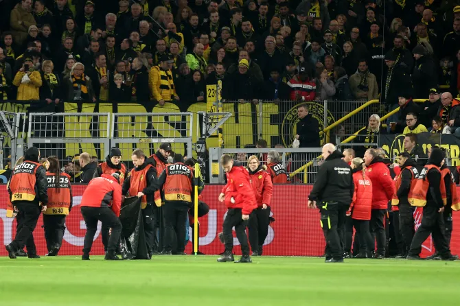 Borussia Dortmund fans throw chocolate coins on pitch, game was delayed.